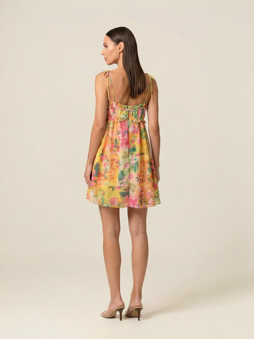 Woman wearing a floral dress on a plain background